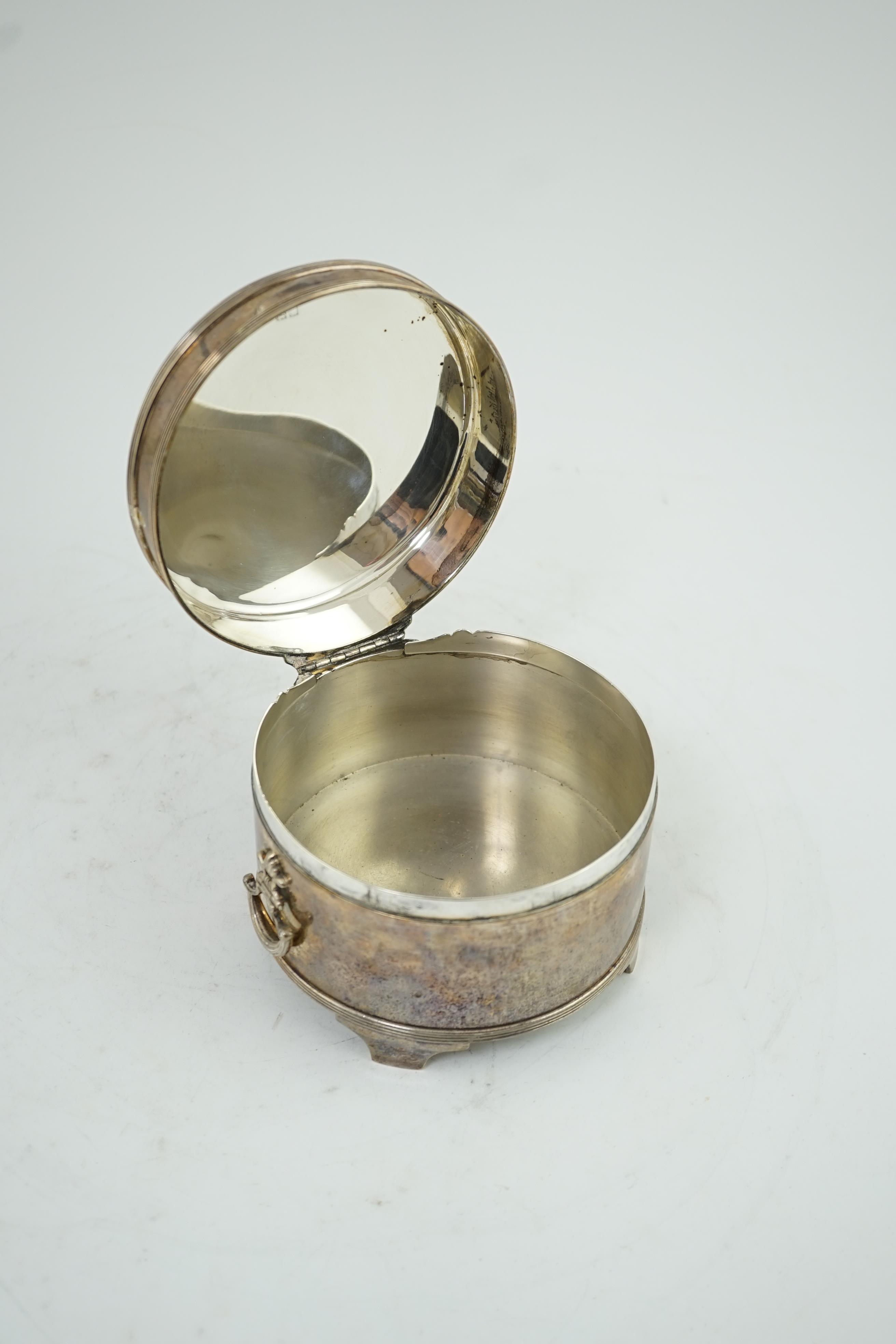 A George V silver circular two handed biscuit box, with hinged cover, by Asprey & Co Ltd